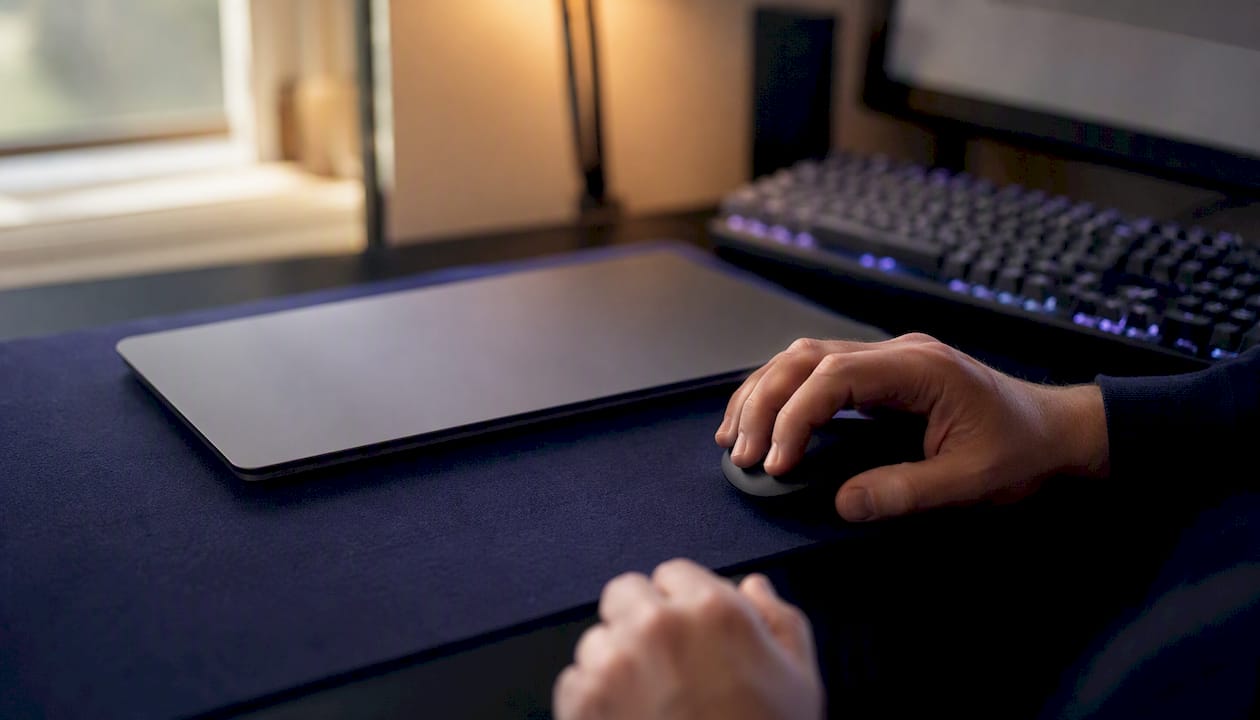Hands clicking mouse by laptop on desk