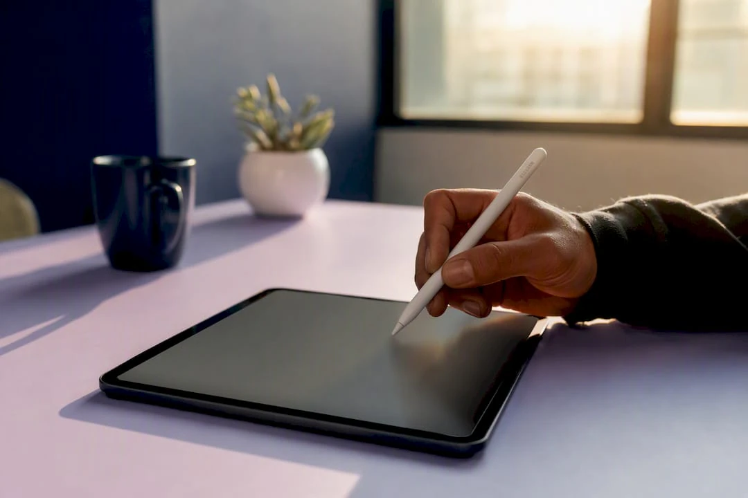 Hand using stylus on tablet with visual editor