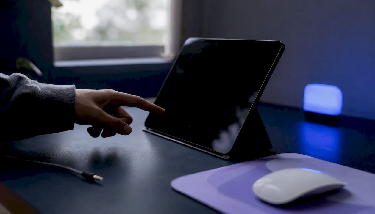 Workspace with hand near tablet and AI concept gear